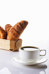 Croissants and cup of coffee on a white background. Breakfast. Selective focus. High key.