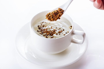 Instant coffee is filled in a cup with hot water. Close up. Selective focus. High key.