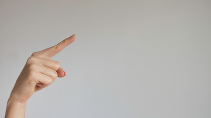 Woman's index finger on a light gray background