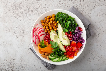 lunch bowl salad with avocado, roasted chickpeas, kale, cucumber, carrot, red cabbage, bell pepper and redish