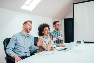 Cheerful business people sitting at the conference table.