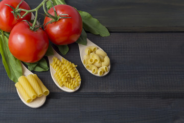 Uncooked pasta in a wooden spoo