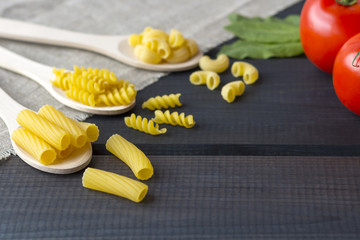 Uncooked pasta in a wooden spoon