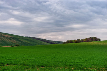 Fototapeta na wymiar Scenic view of beautiful country landscape. Clouds passing above rural fields in South Moravia, Czech Republic.