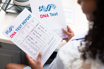 DNA test report in hads of a pregnant woman.