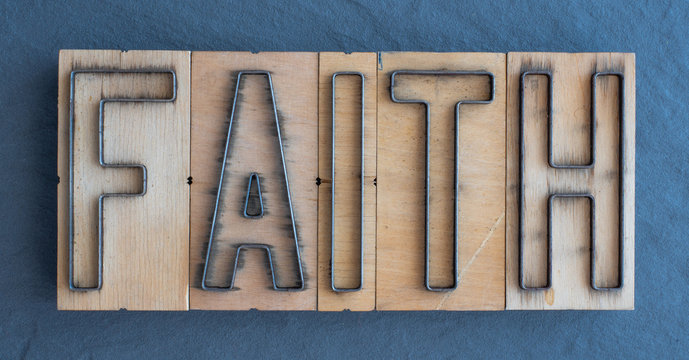 Old wood and steel number plate dies spell out the word FAITH