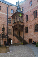 Gripsholm is a castle in Mariefred,  Sweden.  inner courtyard of the castle with an old well, the rays of the sun.