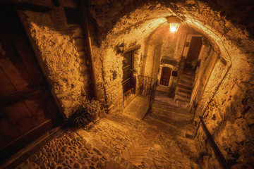 Subterranean street in the night and cozy countryard in the old town of Dolceacqua, Liguria region,...
