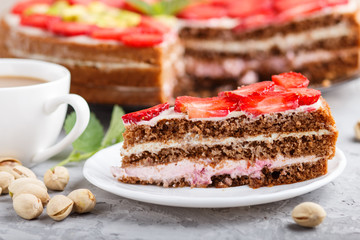 Homemade cake with yoghurt cream, strawberry and pistachio on a gray concrete  background. side view.