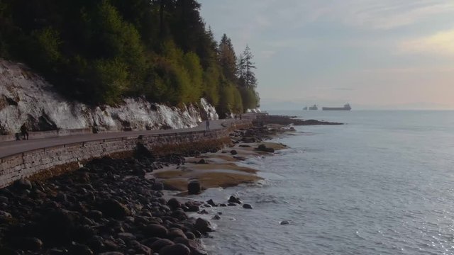 View from the Vancouver sea wall. People walking on by the ocean cliff road.