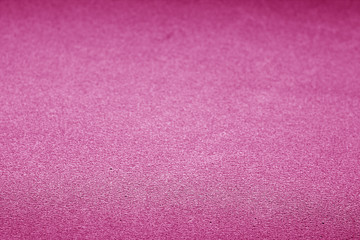 Plastic glittering texture with blur effect in pink color.