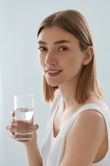 Woman with glass of fresh water in white portrait