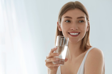 Woman with glass of fresh water in white portrait