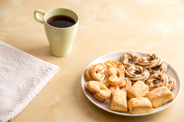 Shortbread cookies and cup with coffee on wooden table