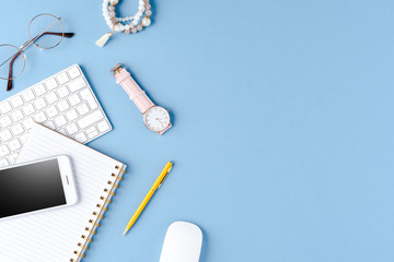 Women's accessories on blue background. Office desktop