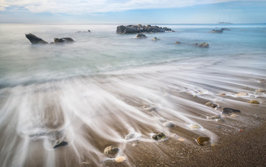 Long exposure shot of Ionian sea vail on the beach of Giardini Naxos, Sicily, Italy