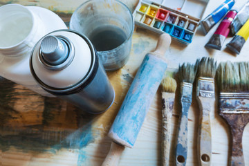 Spray can and tools of artist on the table