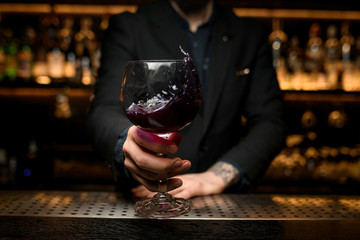 Close shot of splashing alcohol cocktail in bartender's hands