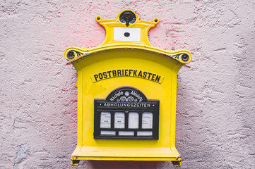Historischer Briefkasten in Deutschland in gelb mit lilafarbener Wand