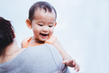 Mother raised her litlle baby on her shoulder