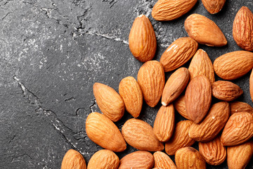 Almonds on a black concrete background close-up. Top view. Place for text.