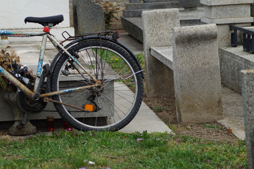 Auf einem Grabstein angelehntes Fahrrad - obrazy, fototapety, plakaty