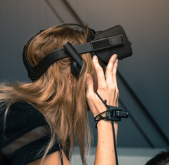 Virtual reality with full immersion. The girl is wearing virtual reality glasses on her head
