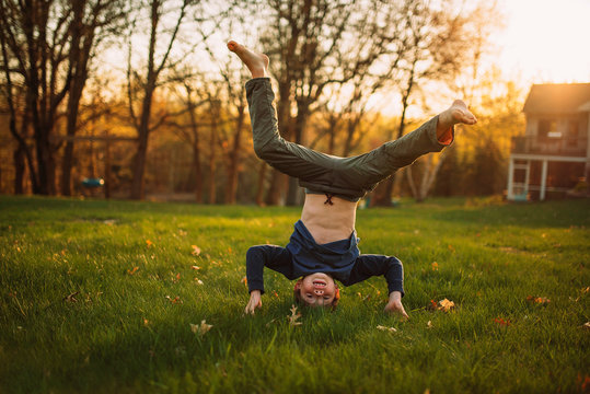 Boy doing a handstand in the garden, United States