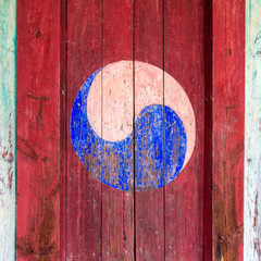 Eum and Yang Symbol, korean variant of Yin and Yang. Colorful retro painting with red background on a wooden door.