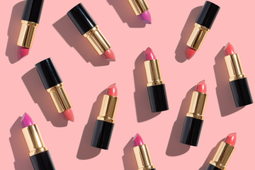 Set of color lipsticks on pink background. Flat lay.