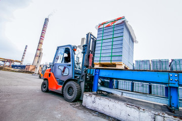 Auto loader with concrete blocks near house-building factory