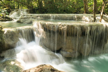 Langzeitbelichtung eines kaskadierten Wasserfalls umgeben von B&auml;umen im Dschungel.