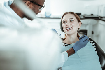 Laughing attractive lady having positive experience with her dentist