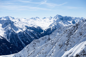Fototapeta na wymiar Bergige Landschaft mit Schnee und blauem Himmel in den Alpen