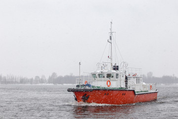 Test the motor boat on the Kama River in the late fall in snowfall