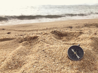 A compass on a sand at the beach.