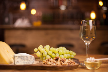 Photo of fresh grapes next to a wineglass on a wooden table