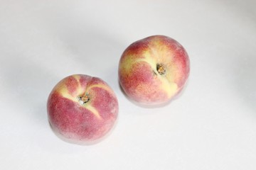 Peaches lying on the table on a white background