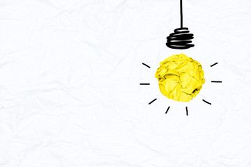 Yellow paper light bulb on wrinkled paper texture with copy space, metaphor creative idea	