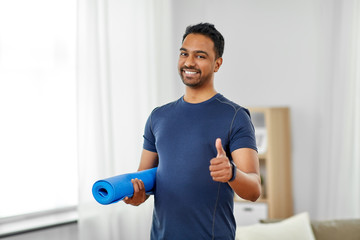 sport and healthy lifestyle concept - smiling indian man with fitness tracker showing thumbs up at home