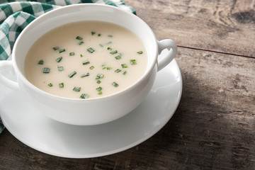 French vichyssoise soup in bowl on wooden table. Copyspace