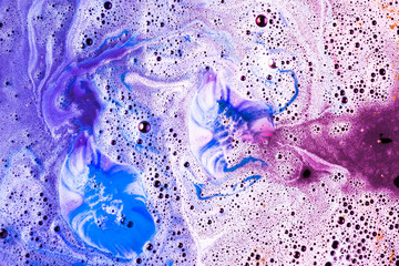 Pink and blue foam after dissolving color bath bomb in water