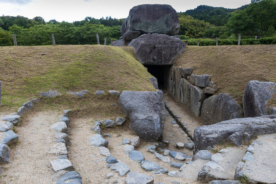 Steps lead entrance of ancient underground tomb covered by large stones