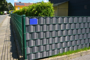 Verzinkter Stahlgitterzaun mit Kunststoff-Sichtschutzfolie als Einfriedung um den Garten eines Wohnhauses © Hermann