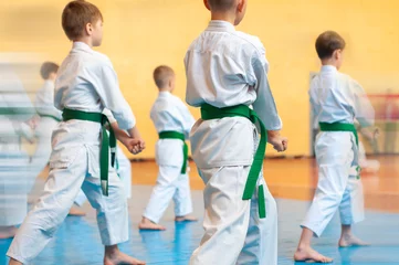 Fotobehang Kids training on karate-do. Banner with space for text. For web pages or advertising printing. Photo without faces. © Uladzimir