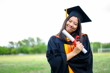 Long haired female students wearing black ruffle dresses expressing joy on graduation at the...