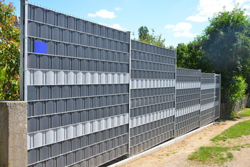 Verzinkter Stahlgitterzaun mit Kunststoff-Sichtschutzfolie als Einfriedung um den Garten eines Wohnhauses © Hermann