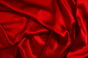 Red silk or satin luxury fabric texture can use as abstract background. Top view.