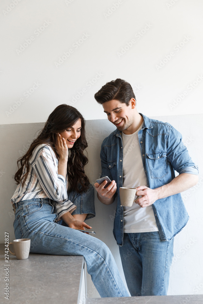 Wall mural Attractive young couple drinking coffee