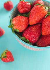 Juicy, ripe strawberries in a colorful turquoise bowl, top view